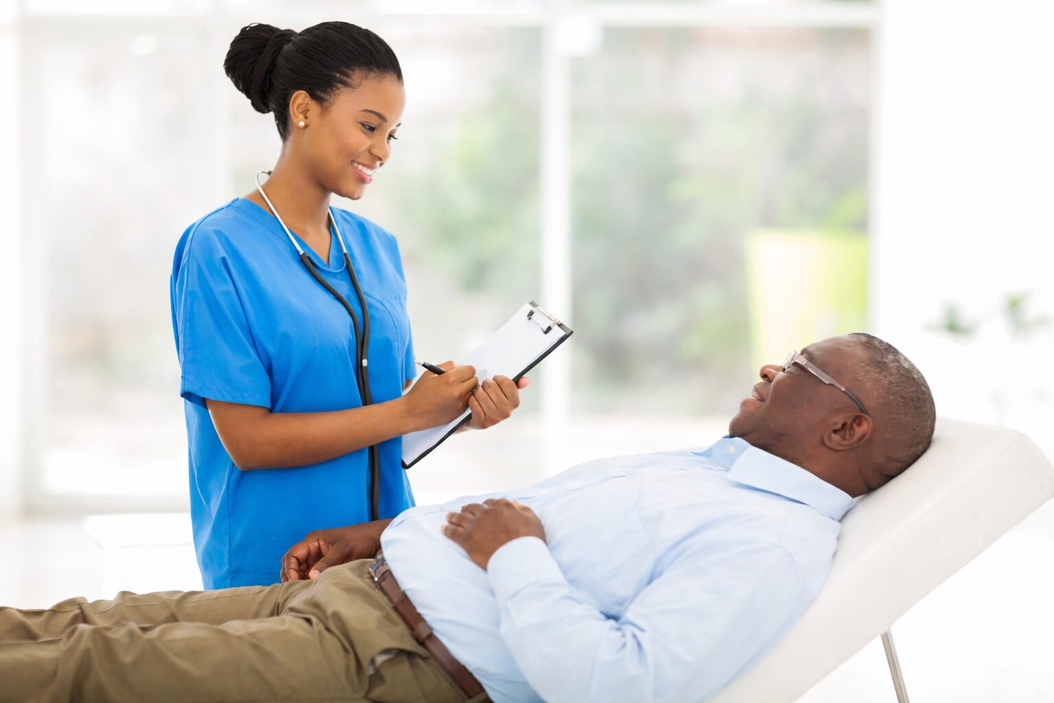 Nigerian patient consulting with nurse in hospital while planning medical treatment and fundraising for bone marrow transplant in India
